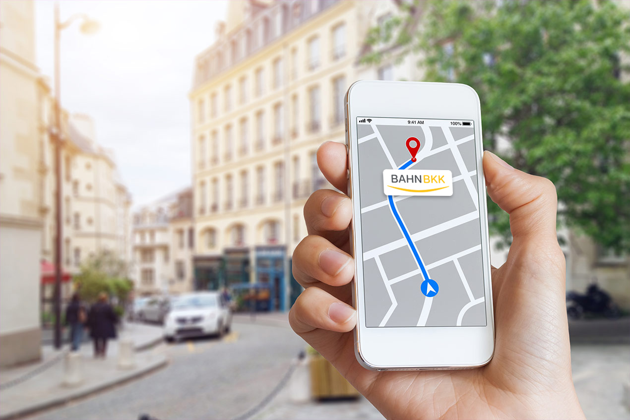 Jemand hält ein Smartphone mit Karten-App in der Hand.