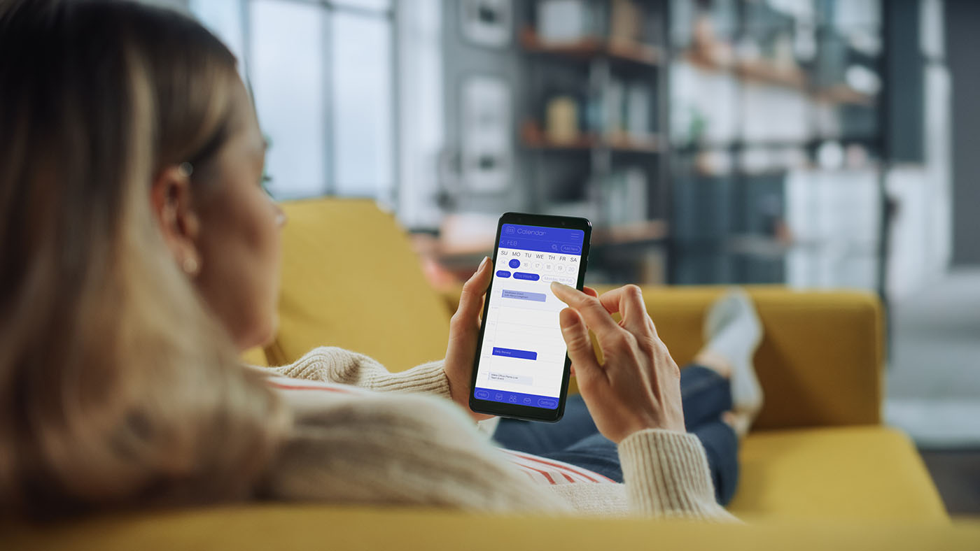 Frau auf der Couch mit einem Smartphone