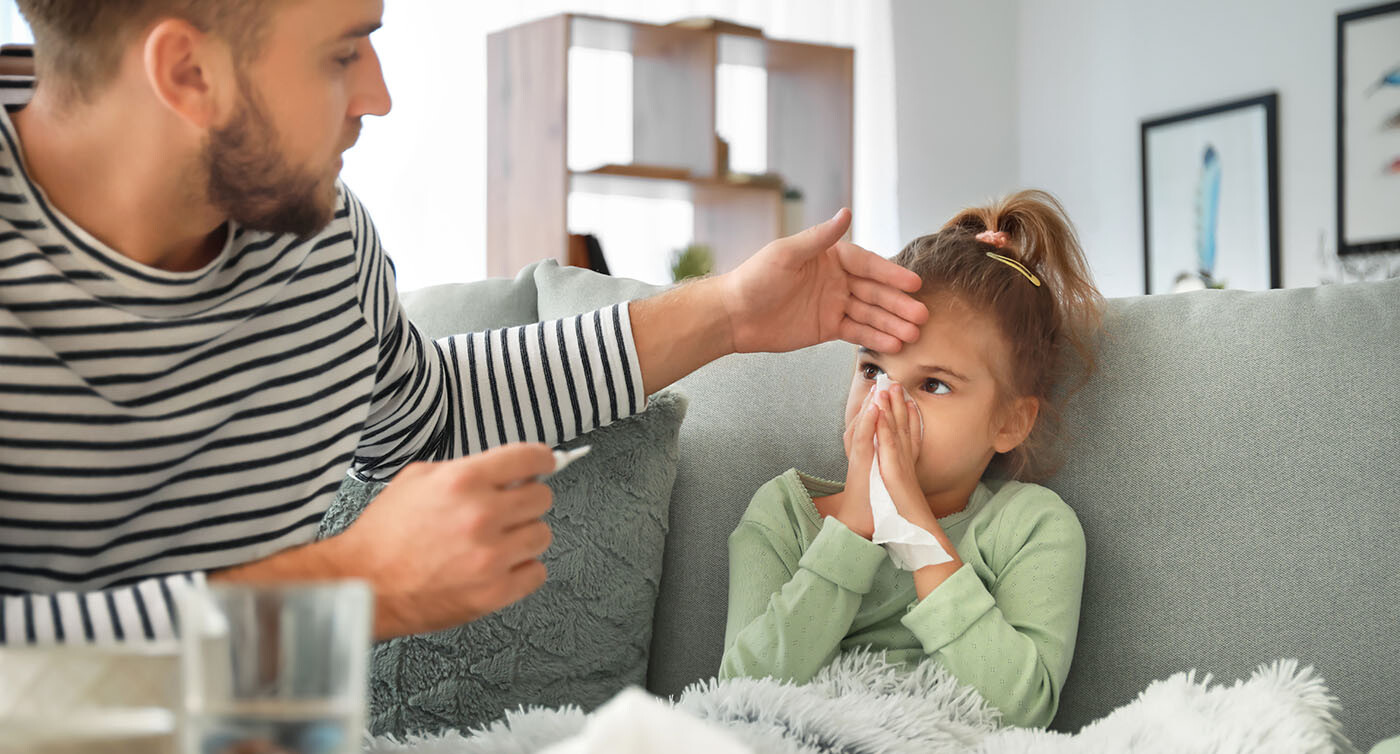 Junger Vater misst bei seiner kranken kleinen Tochter Fieber