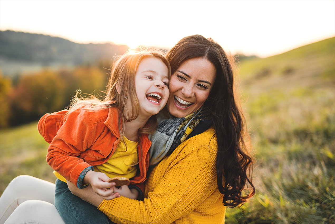 Eine lachende junge Mutter mit ihrer lachenden Tochter auf Mutter-Kind-Kur