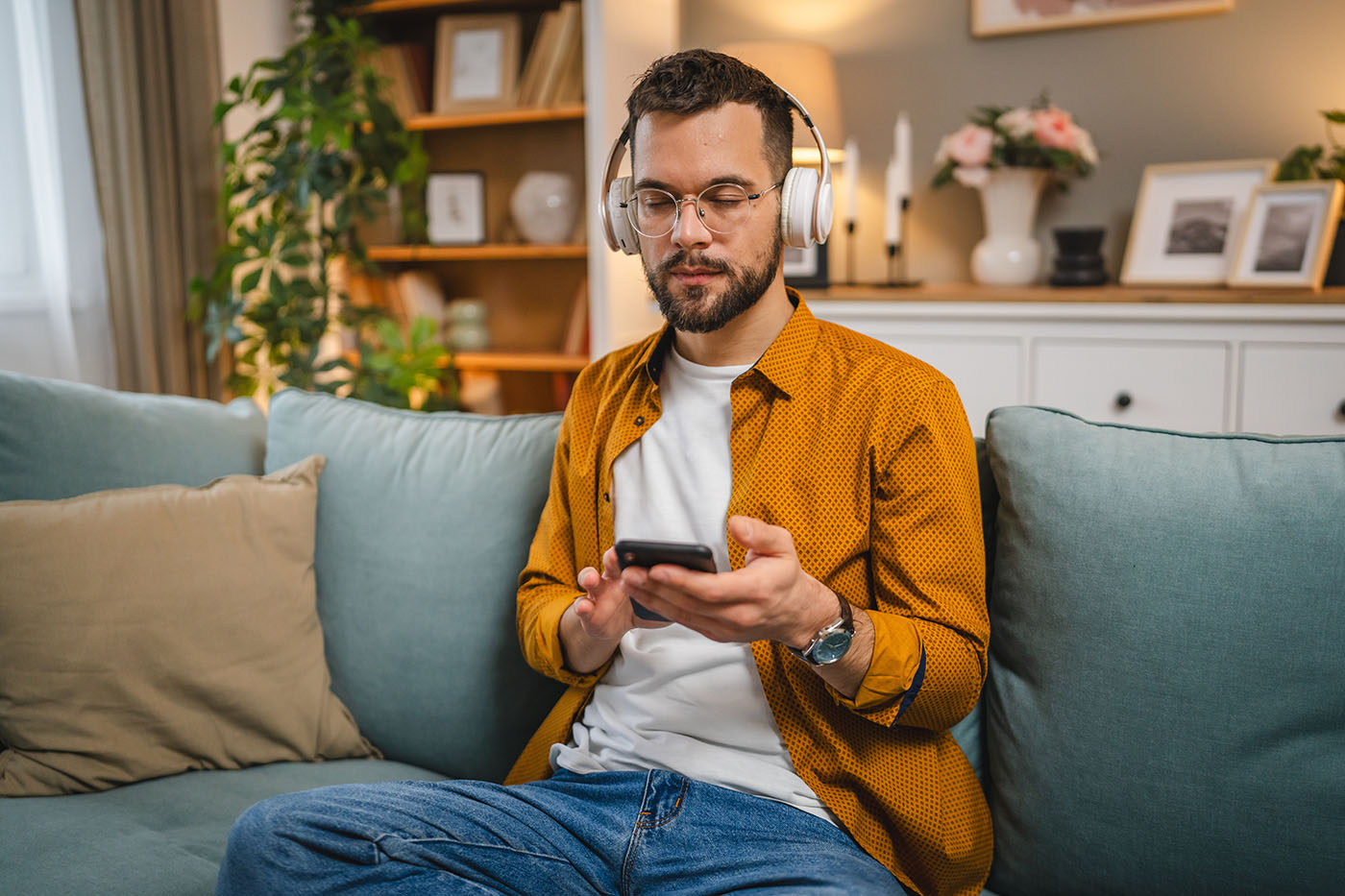 Mann mit einem Smartphone auf dem Sofa