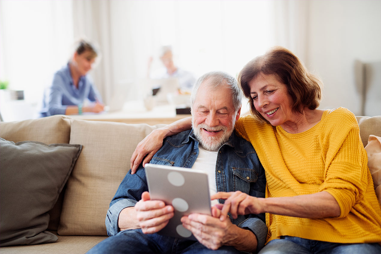 Ehepaar, dass sich am Tablet um die Vorsorgevollmacht und Patientenverfügung kümmert