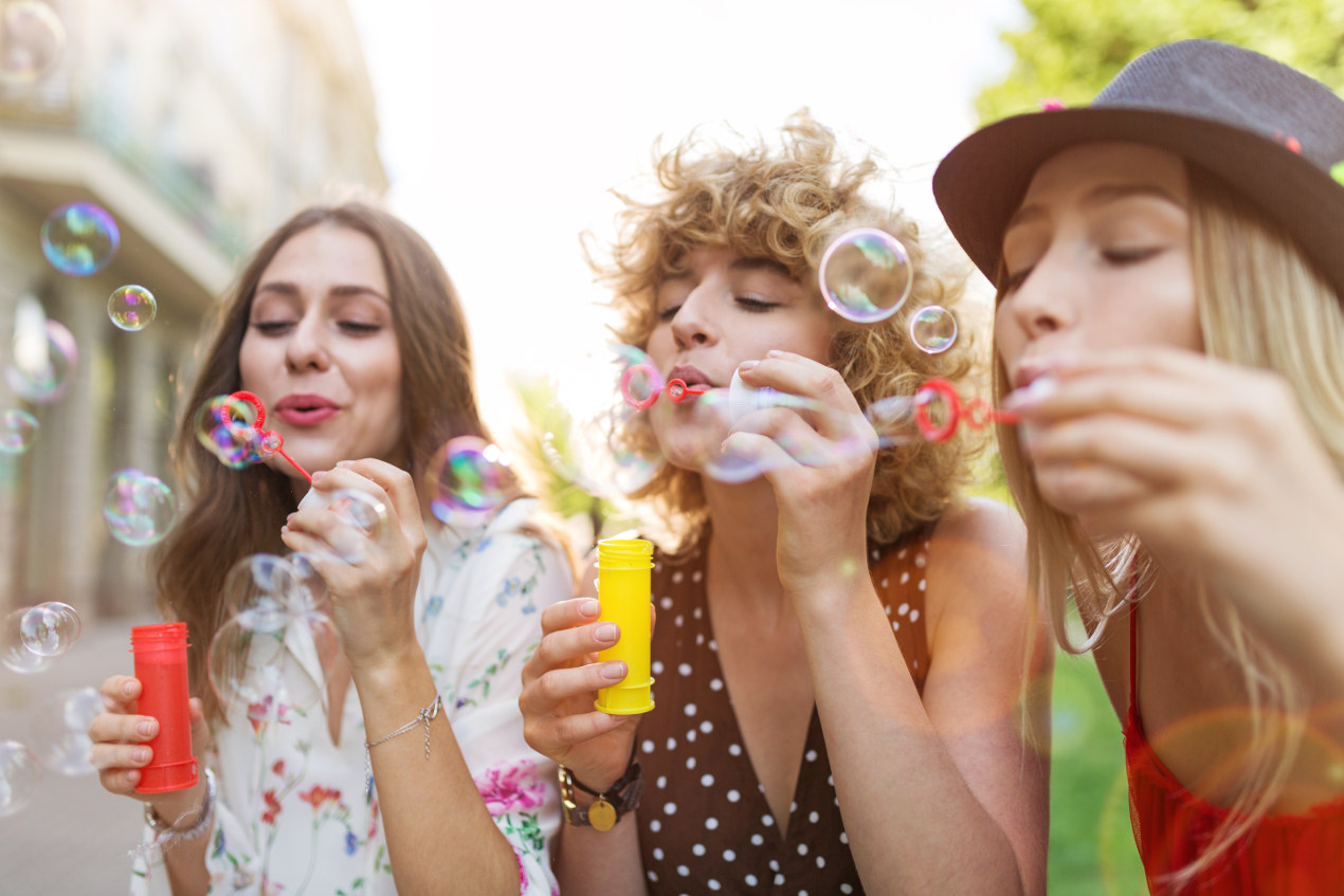 Drei Frauen pusten Seifenblasen