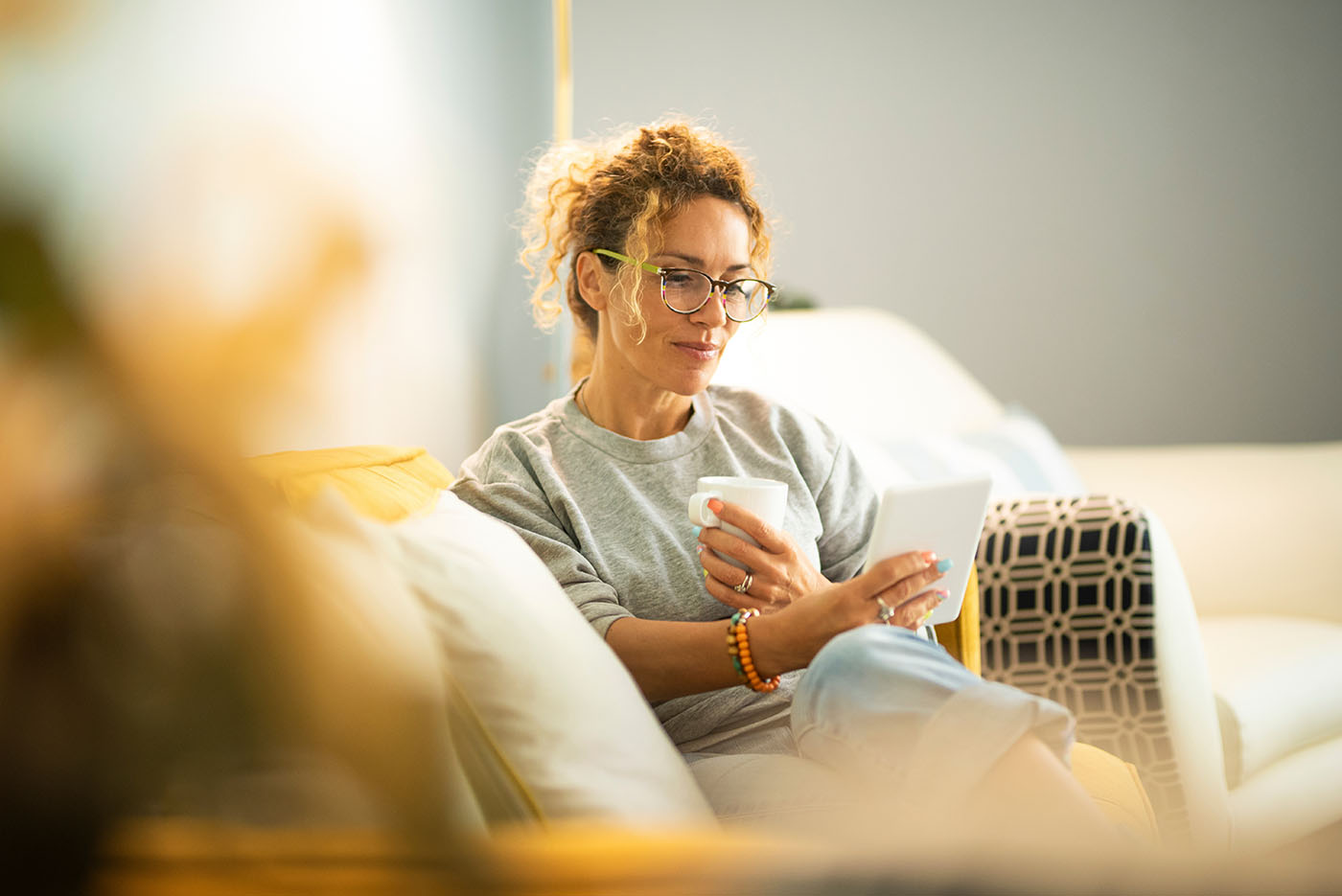 Frau, die auf der Couch sitzt und auf einen Zettel schaut