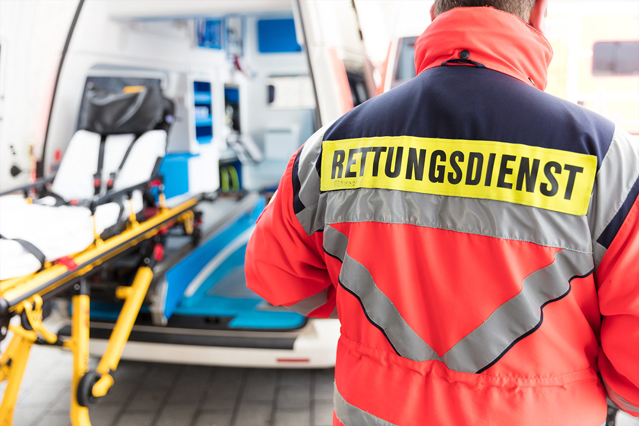 Foto eines Rettungssanitäters vor einem Krankenwagen